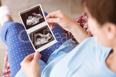 Pregnant woman looking at ultrasound scans