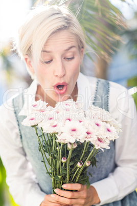 Pretty blonde woman holding bunch of flowers