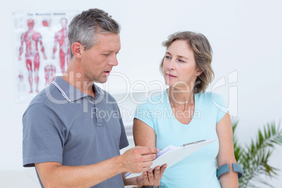 Woman using crutch and talking with her doctor