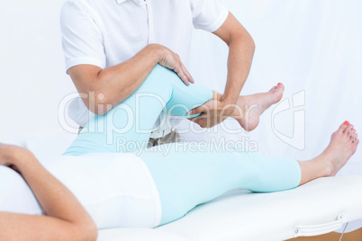 Physiotherapist doing leg massage to his patient