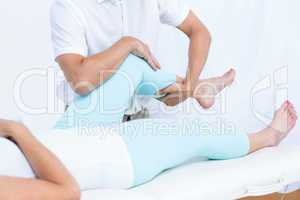 Physiotherapist doing leg massage to his patient