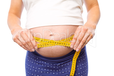 Pregnant woman measuring her bump