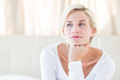 Pretty blonde woman sitting on the bed