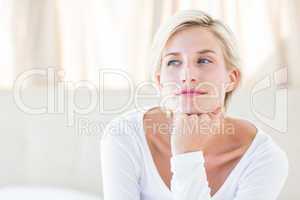 Pretty blonde woman sitting on the bed