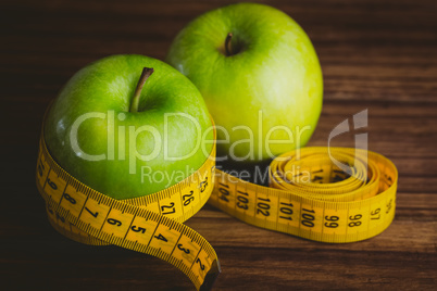 Green apples with measuring tape