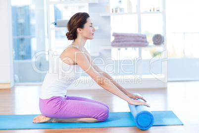 Smiling woman sitting on exercise mat