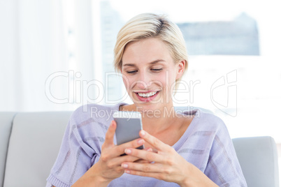 Pretty blonde woman texting with her mobile phone