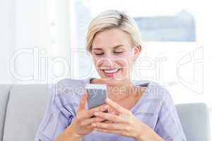 Pretty blonde woman texting with her mobile phone