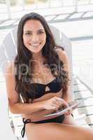 Beautiful young woman relaxing and using tablet pc