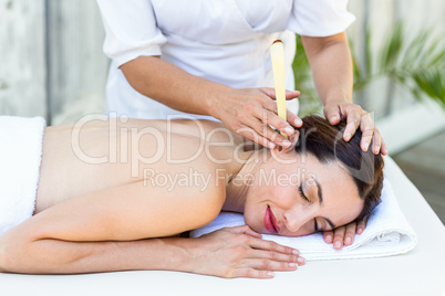 Relaxed brunette getting an ear candling treatment