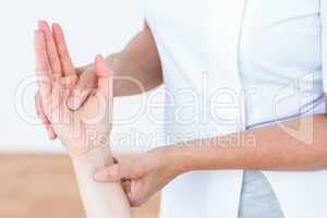 Physiotherapist examining her patients hand
