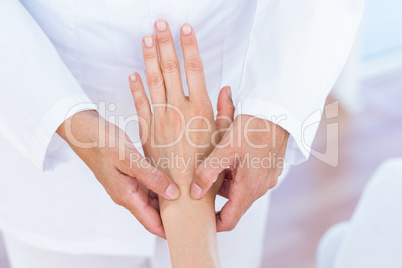 Doctor examining her patients wrist