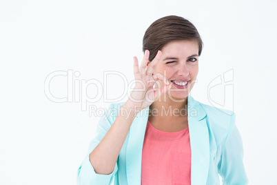 Smiling young woman gesturing okay sign