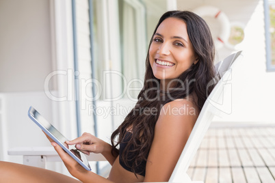 Beautiful young woman relaxing and using tablet pc