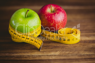 Green and red apples with measuring tape