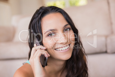 Pretty brunette calling with her mobile phone