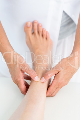 Physiotherapist massaging her patients ankle Physiotherapist massaging her patients ankle