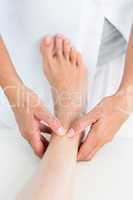 Physiotherapist massaging her patients ankle