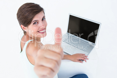 Attractive woman using laptop with thumb up