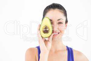 Pretty woman showing half of an avocado