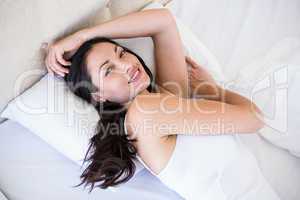 Pretty brunette smiling on bed