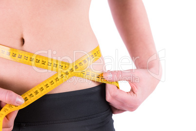 Slim woman measuring waist with tape measure