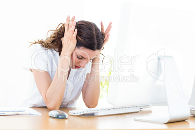 Upset businesswoman sitting at her desk