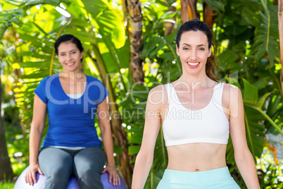 Smiling woman and her trainer looking at camera