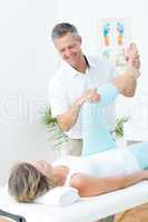 Physiotherapist doing leg massage to his patient