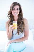 Happy woman drinking at glass of orange juice