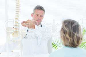 Doctor showing his patient a spine model