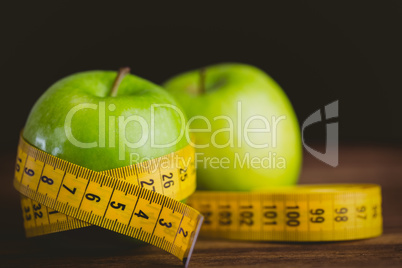 Green apples with measuring tape