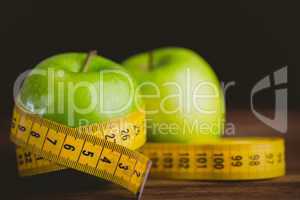 Green apples with measuring tape