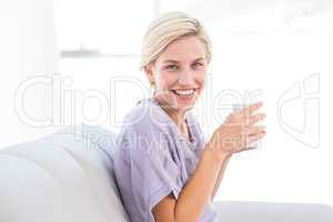 Pretty blonde woman relaxing on the couch and holding a mug