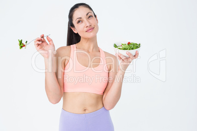 Smiling brunette eating salad