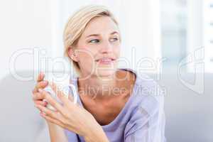 Pretty blonde woman relaxing on the couch and holding a mug