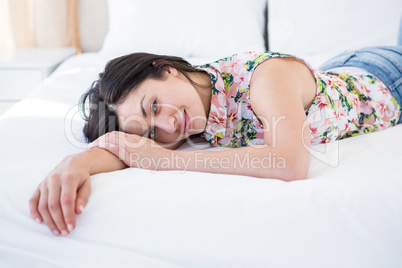 Pretty brunette looking at camera and lying on bed