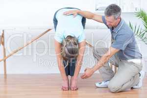 Physiotherapist helping his patient stretching