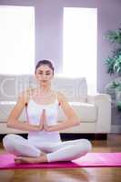 Fit woman doing yoga on mat