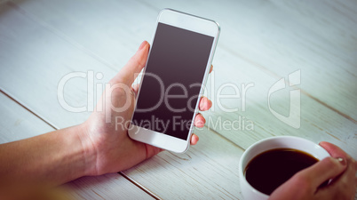 Woman using her smartphone with coffee