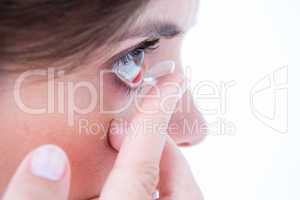 Close up on pretty woman applying contact lens