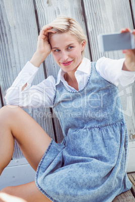 Pretty blonde woman taking selfie