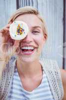 Pretty blonde woman grimacing with cupcake