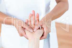 Physiotherapist massaging her patients hand