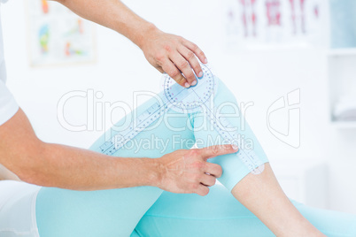 Doctor measuring knee with goniometer