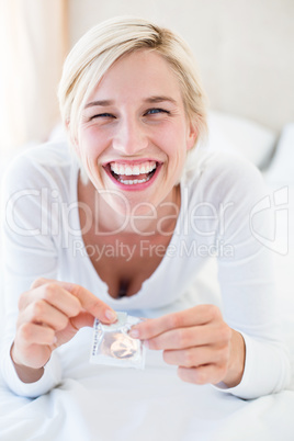 Smiling blonde woman holding condom