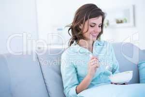 Pretty woman eating bowl of salad