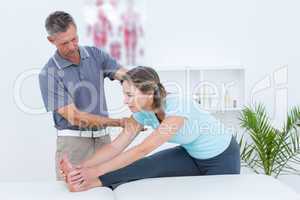 Physiotherapist helping his patient stretching