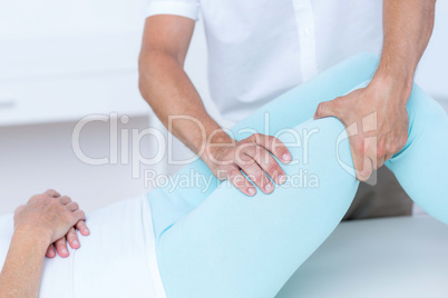 Physiotherapist doing leg massage to his patient