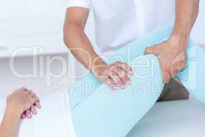 Physiotherapist doing leg massage to his patient